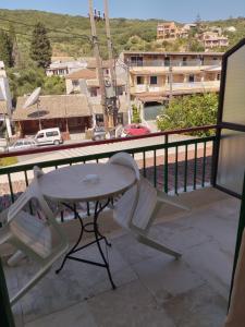 een tafel en stoel op een balkon met uitzicht op de stad bij Jimmy's Apartments in Moraitika
