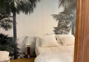 アヌシーにあるcharmant appartement Annecyのソファ付きのリビングルーム、ヤシの木2本