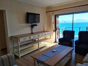 a living room with a television and a couch and a table at Point Village Accommodation - Erin 5 in Mossel Bay