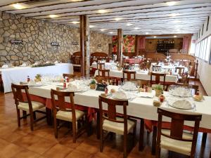 Un gran comedor con mesas y sillas blancas. en Norte Hotel, en Villanueva de Gállego