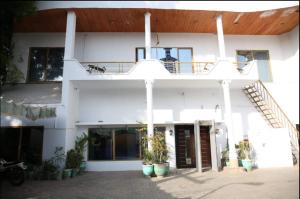 ein weißes Gebäude mit einer Treppe und einem Balkon in der Unterkunft Hotel OR Odyssey Residence in Multan