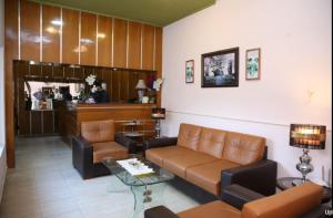 Hotel OR Odyssey Residence في ملتان: غرفة معيشة مع أريكة وطاولة