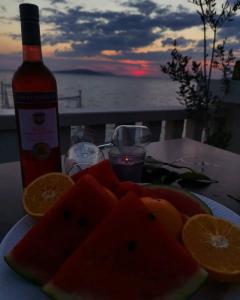 un plato de fruta en una mesa con una botella de vino en Guesthouse Villa Paškal en Zaostrog