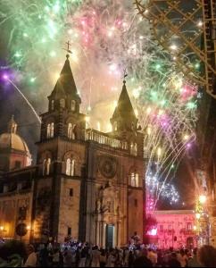 Un vieux bâtiment avec des feux d'artifice devant lui dans l'établissement Casa ABBATUZZU, à Acireale