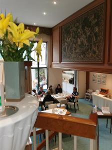 a group of people sitting at tables in a restaurant at Hotel Cristal in Nürnberg