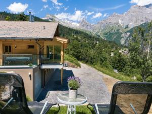 a house in the mountains with a table and chairs at Chalet Paisible by Interhome in Ovronnaz