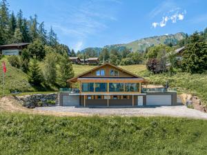 a house on a hill with mountains in the background at Chalet Paisible by Interhome in Ovronnaz