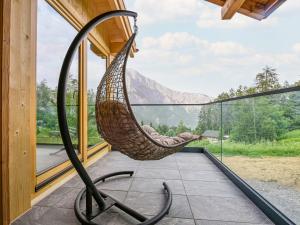 a hammock on the porch of a house with a view at Chalet Paisible by Interhome in Ovronnaz