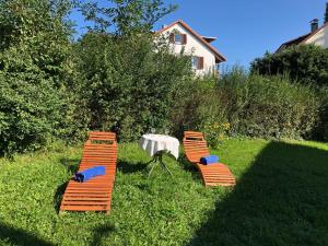 two orange chairs and a table in the grass at Apartment Erica-1 by Interhome in Überlingen