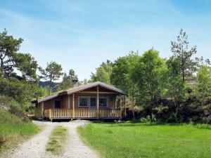 a cabin in the woods with a dirt road in front at Holiday Home Solbakken - FJS547 by Interhome in Gjølanger