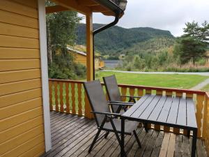 a porch with two chairs and a table on it at Holiday Home Solbakken - FJS547 by Interhome in Gjølanger