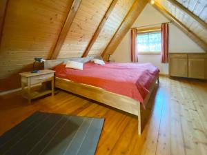 ein Schlafzimmer mit einem roten Bett im Dachgeschoss in der Unterkunft Holiday Home Backhäusle by Interhome in Unterehlenbogen
