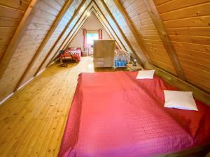 ein Schlafzimmer mit einem roten Bett im Dachgeschoss in der Unterkunft Holiday Home Backhäusle by Interhome in Unterehlenbogen