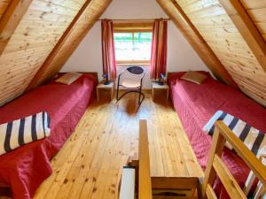 a attic room with two beds and a table at Holiday Home Backhäusle by Interhome in Unterehlenbogen