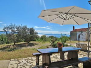 una mesa de picnic con una sombrilla en el patio en Apartment Marinella-3 by Interhome, en Labin