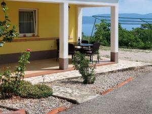 Un patio con una mesa y sillas en una casa. en Apartment Marinella-3 by Interhome, en Labin