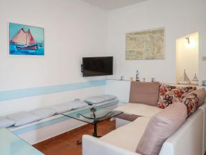Una sala de estar con un sofá y un televisor. en Apartment Marinella-3 by Interhome, en Labin