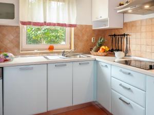 Una cocina con gabinetes blancos y un fregadero y una ventana. en Apartment Marinella-3 by Interhome, en Labin 21 fotos más