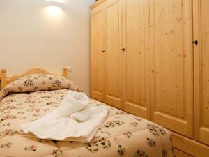 1 dormitorio con 1 cama y armario de madera en Apartment Cjase Fravins-3 by Interhome, en Raveo