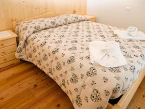 a bedroom with a bed with a white comforter at Apartment Cjase Fravins-3 by Interhome in Raveo