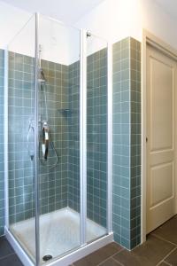 a bathroom with a shower with blue tiles at Apartment Cjase Fravins-3 by Interhome in Raveo