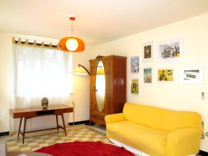 a living room with a yellow couch and a table at Holiday Home Villa Sarezzano by Interhome in Sarezzano