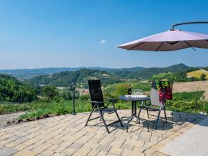 eine Terrasse mit einem Tisch, Stühlen und einem Sonnenschirm in der Unterkunft Holiday Home Casa Chiara - SIC400 by Interhome in Serralunga di Crea