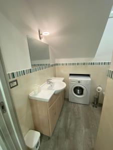 a bathroom with a sink and a washing machine at La casetta del borgo in Agerola +37 photos