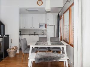 uma pequena cozinha com uma mesa branca e cadeiras em Holiday Home Karhunvartijan tupa a6 by Interhome em Ruka