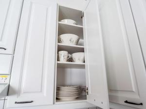 a cupboard with plates and dishes in it at Holiday Home Karhunvartijan tupa a6 by Interhome in Ruka