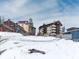 a snow covered street in a city with buildings at Holiday Home Karhunvartijan tupa a6 by Interhome in Ruka