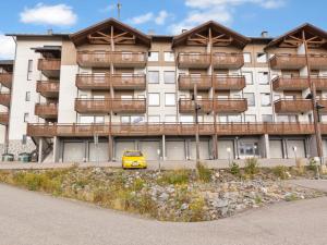 a yellow car parked in front of a building at Holiday Home Ski chalets vii 7403 by Interhome in Ylläs