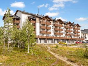 un gran edificio de apartamentos con una carretera delante de él en Holiday Home Ski chalets vii 7403 by Interhome, en Ylläs