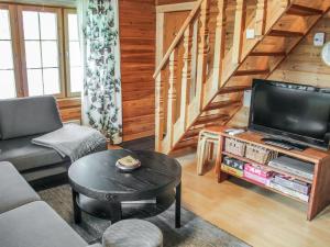 ein Wohnzimmer mit einem TV und einer Treppe in der Unterkunft Holiday Home Saikulevi by Interhome in Levi