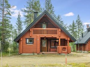 uma cabana de madeira na floresta com um alpendre em Holiday Home Fassen maja by Interhome em Ylläsjärvi