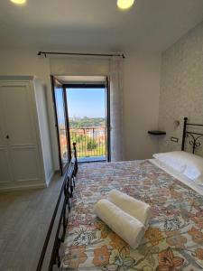 a bedroom with a large bed with a large window at La casetta del borgo in Agerola