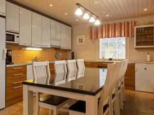 レヴィにあるHoliday Home Jutapirtti by Interhomeの白いキャビネット、テーブルと椅子付きのキッチンが備わります。