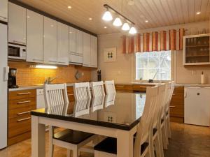 eine Küche mit weißen Schränken und einem Tisch und Stühlen in der Unterkunft Holiday Home Jutapirtti by Interhome in Levi