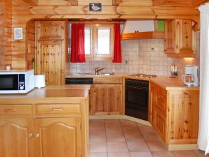 a kitchen with wooden cabinets and a stove top oven at Chalet Chalet Boucaro by Interhome in Nendaz