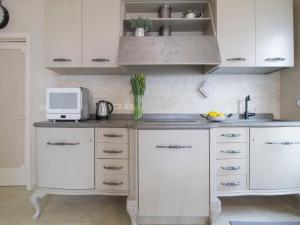 a kitchen with white cabinets and a microwave at Apartment Agave by Interhome in Civitella Marittima