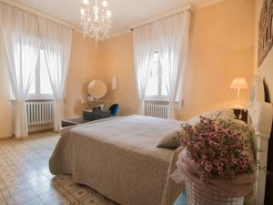 a bedroom with a large bed and two windows at Apartment Agave by Interhome in Civitella Marittima