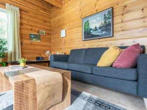 KukkolaにあるHoliday Home Lehtola by Interhomeの青いソファと木製の壁が備わるリビングルーム