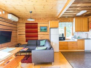 uma sala de estar com um sofá e uma cozinha em Holiday Home Villa viettorinne by Interhome em Vuokatti