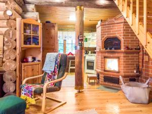- un salon avec une cheminée en briques et une chaise dans l'établissement Holiday Home Keskiniemi by Interhome, à Nissinaho