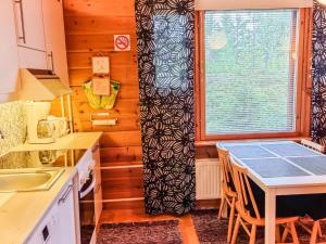 a kitchen with a table with chairs and a window at Holiday Home Lähikaltio 329 by Interhome in Äkäslompolo