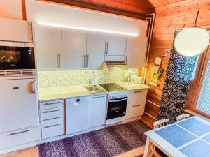 アカスロンポロにあるHoliday Home Lähikaltio 329 by Interhomeの白いキャビネットとシンク付きのキッチン