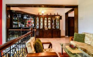 a bar with a wooden cabinet with alcohol bottles at Stunning luxury Villa in Goa India in Colva