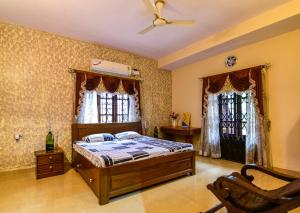 a bedroom with a bed and two windows at Stunning luxury Villa in Goa India in Colva