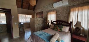 a bedroom with a bed and a brick wall at Loerie Escape - Marloth Park in Marloth Park