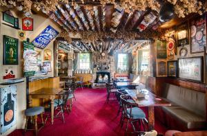 um restaurante com mesas e cadeiras e uma lareira em The Red Lion em Cambridge